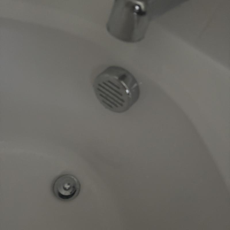 Bathtub overflow drain and faucet fixture close-up