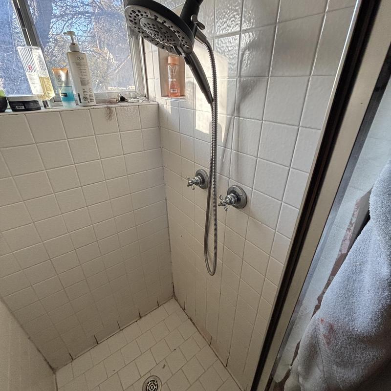Shower drain with handheld showerhead in tiled stall