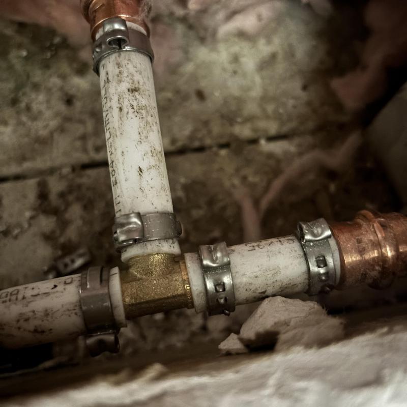 PEX piping with copper fittings and clamps in wall