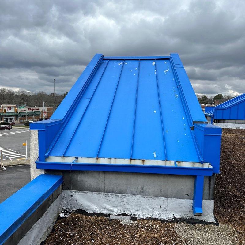 Blue standing seam metal roof with hail damage