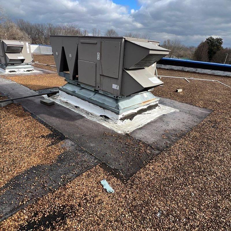 Commercial rooftop HVAC unit with sealed base and gravel roof