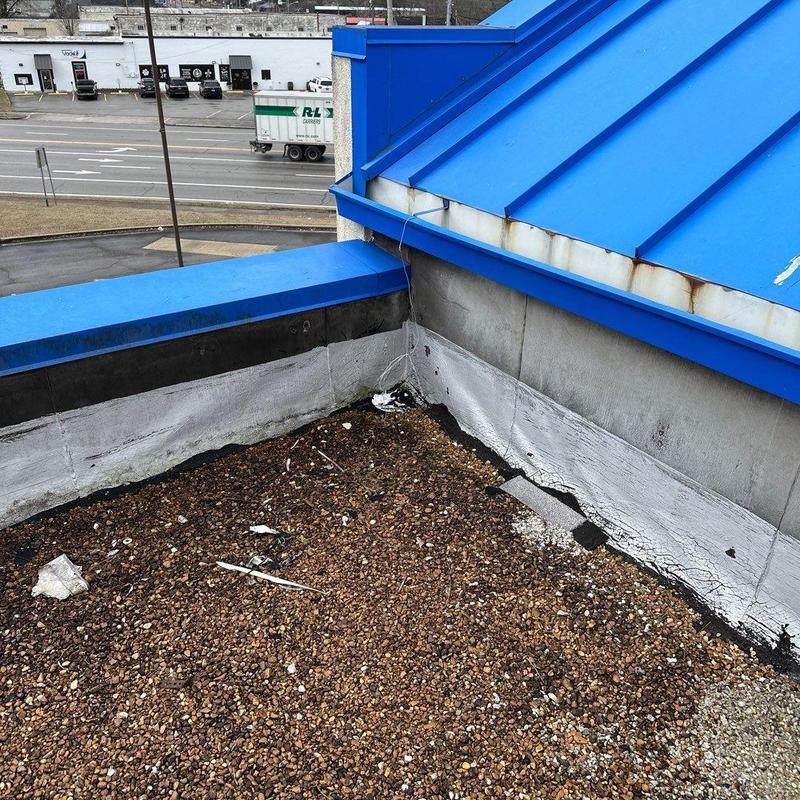 Gravel roofing membrane seams with rusted blue metal trim