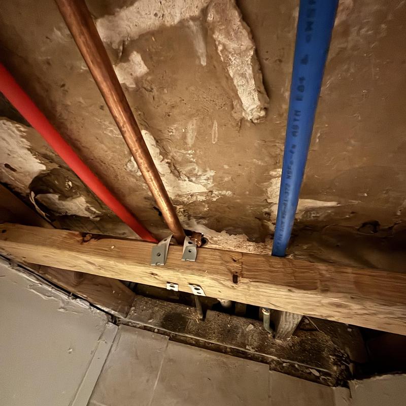 Copper and PEX water supply pipes secured to ceiling joist