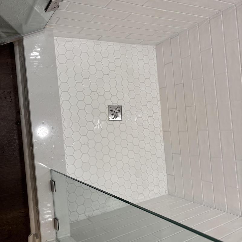 Shower drain with hex tile floor and glass door
