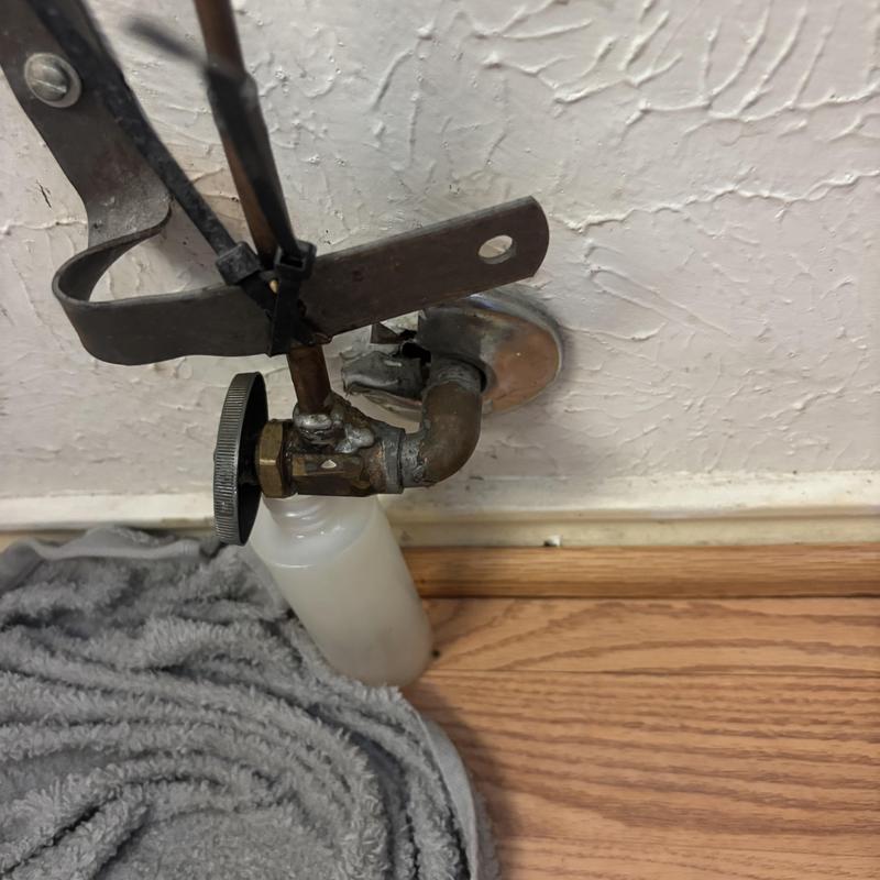 Angle stop valve with catch pan below wood floor