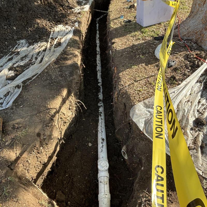 4-inch PVC main sewer line installation in trench