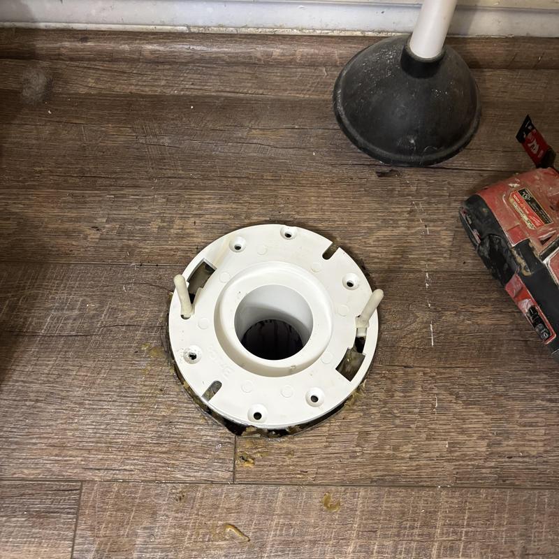 PVC toilet flange installed on wooden floor