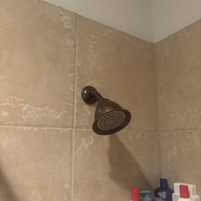 Showerhead installation on beige tiled wall