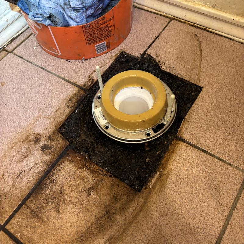 PVC toilet flange installation on tiled floor