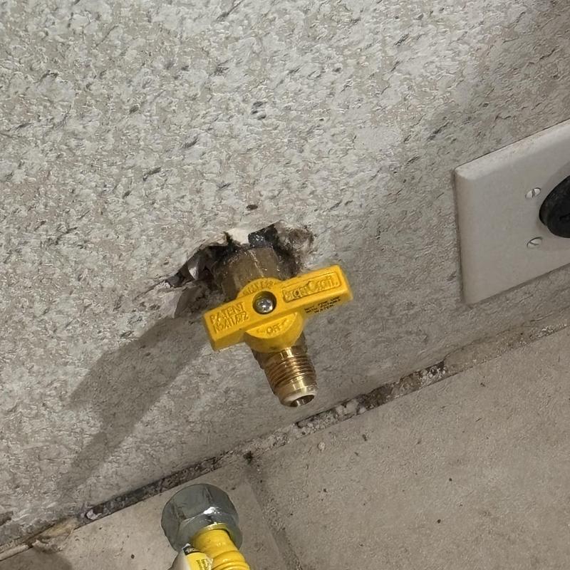 Gas shut off valve installed on wall near outlet