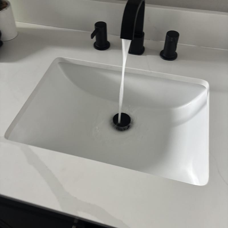 Bathroom sink faucet with black fixtures and running water