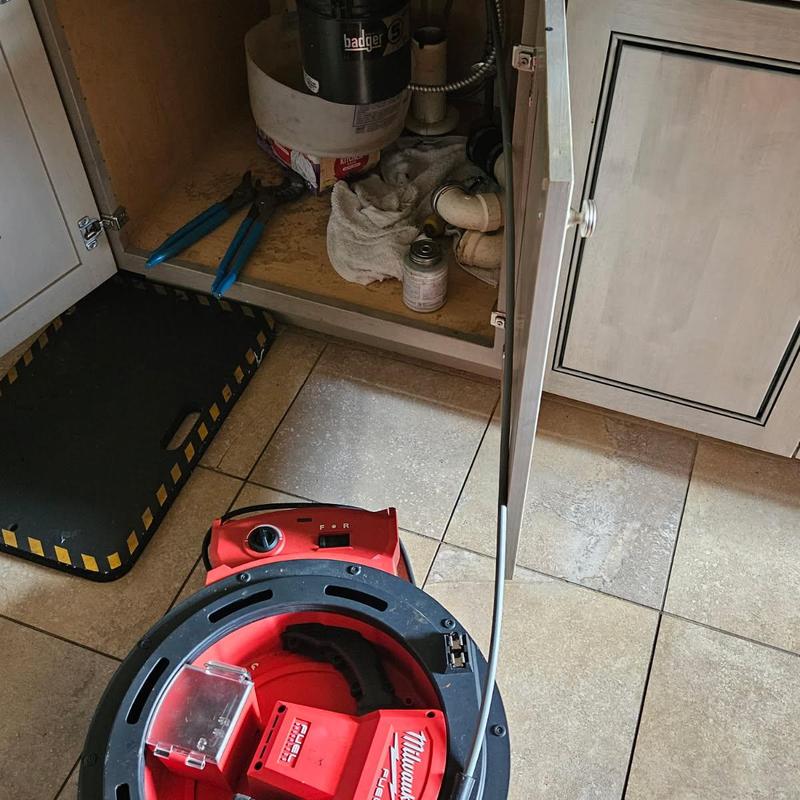 Kitchen sink drain line with plumbing snake tool