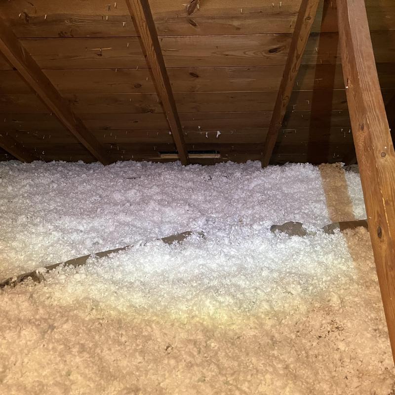 Attic cellulose insulation installed under wooden roof beams Attic cellulose insulation installed under wooden roof beams