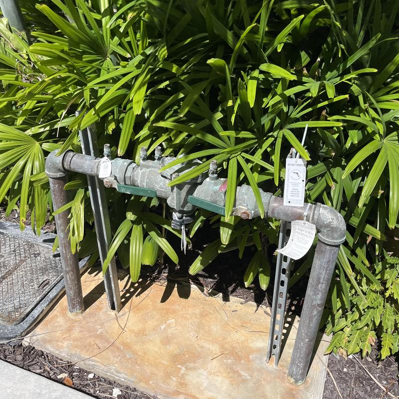 Backflow prevention device with inspection tags outdoors