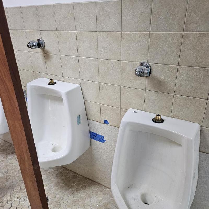 Urinal installation with wall-mounted flush valves