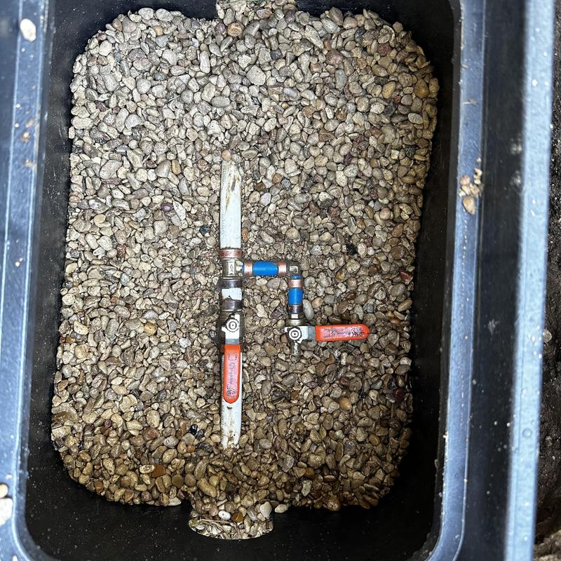 PEX manifold system with drain valves in gravel-filled box