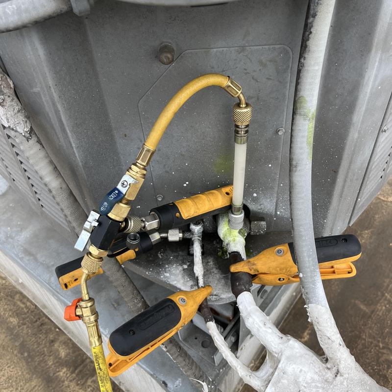 Refrigerant gauge hoses on HVAC condenser unit Refrigerant gauge hoses on HVAC condenser unit