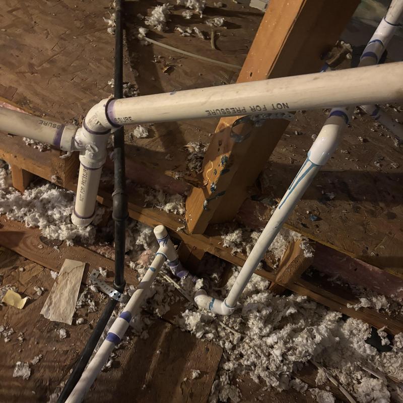 Condensate drain line rerouted in attic plumbing system