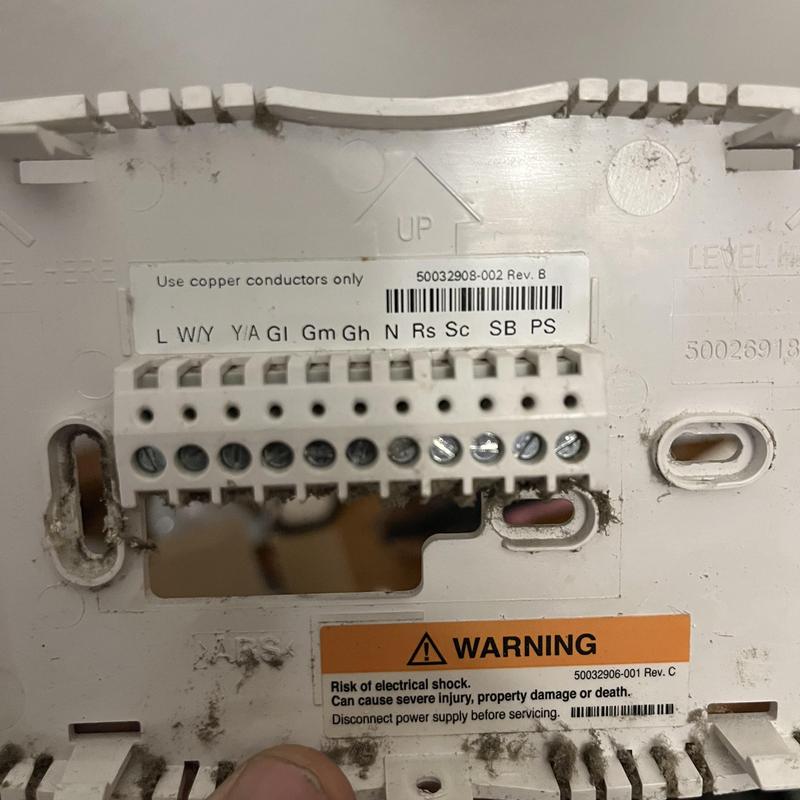 Thermostat wiring terminal block with safety warning label