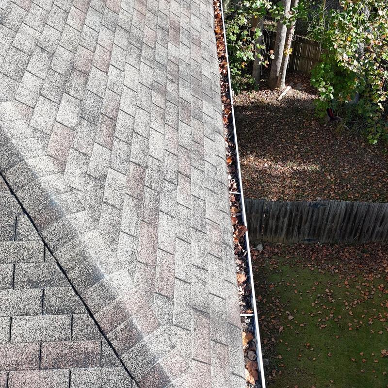 Roof shingles and gutter filled with leaves inspection