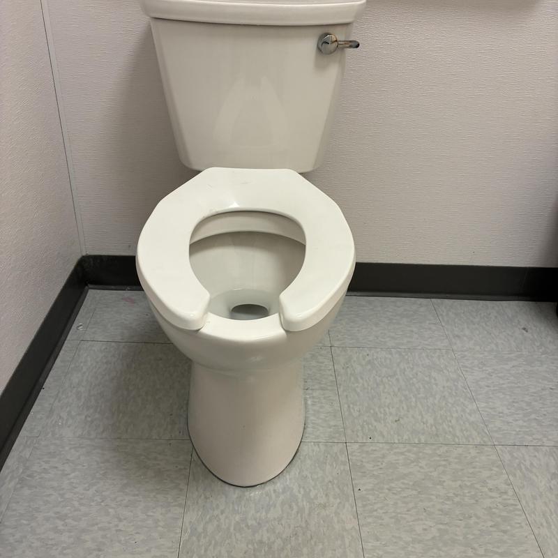 Commercial toilet with open front seat reset in bathroom