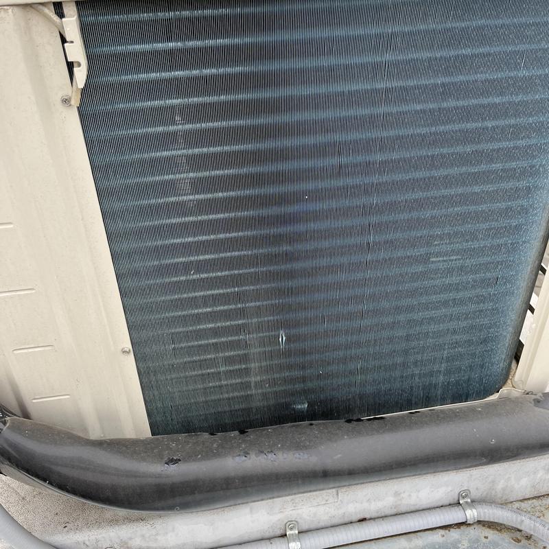 Air conditioner condenser coil during maintenance check Air conditioner condenser coil during maintenance check