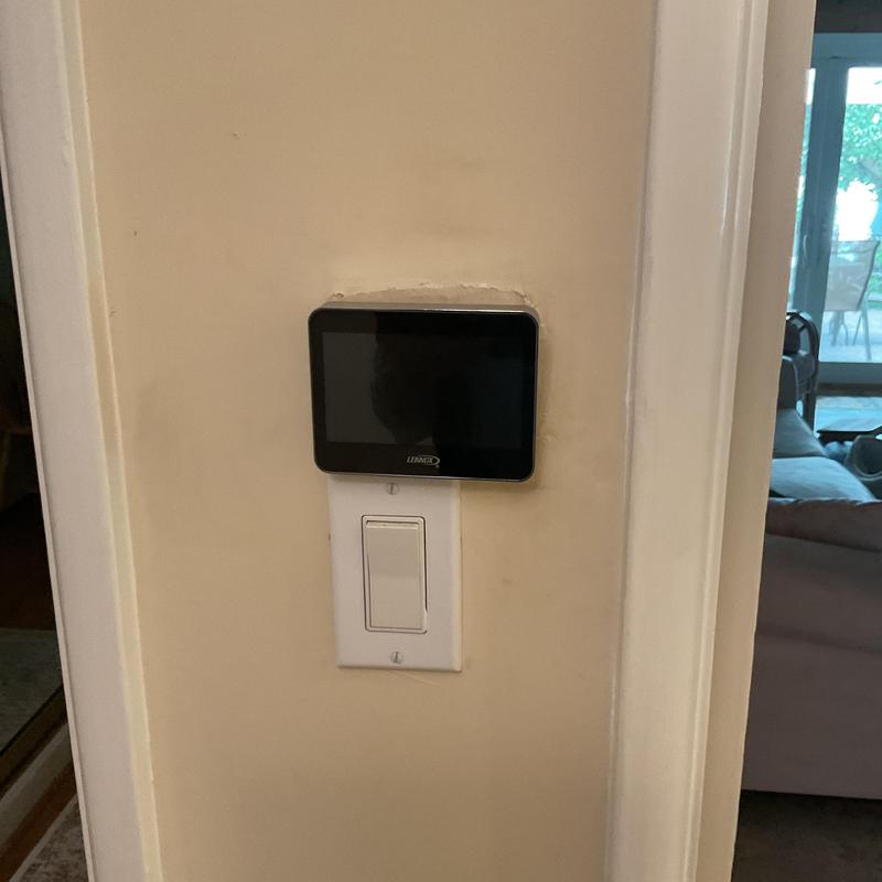 Lennox thermostat and light switch on wall