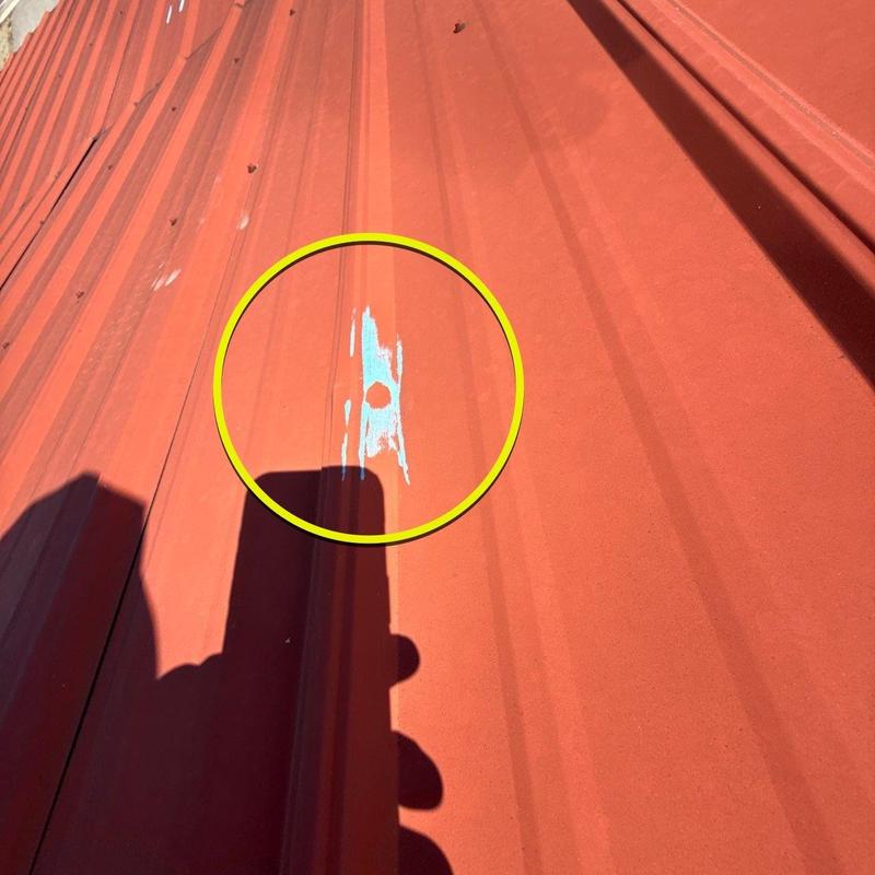 Metal roof panel with rust hole damage marked