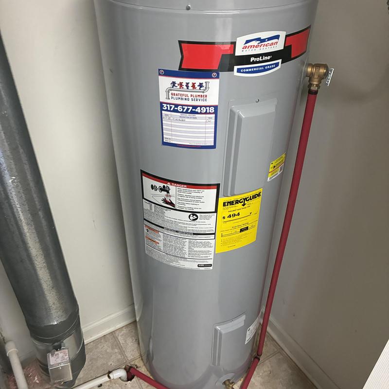 Electric water heater installation with red piping