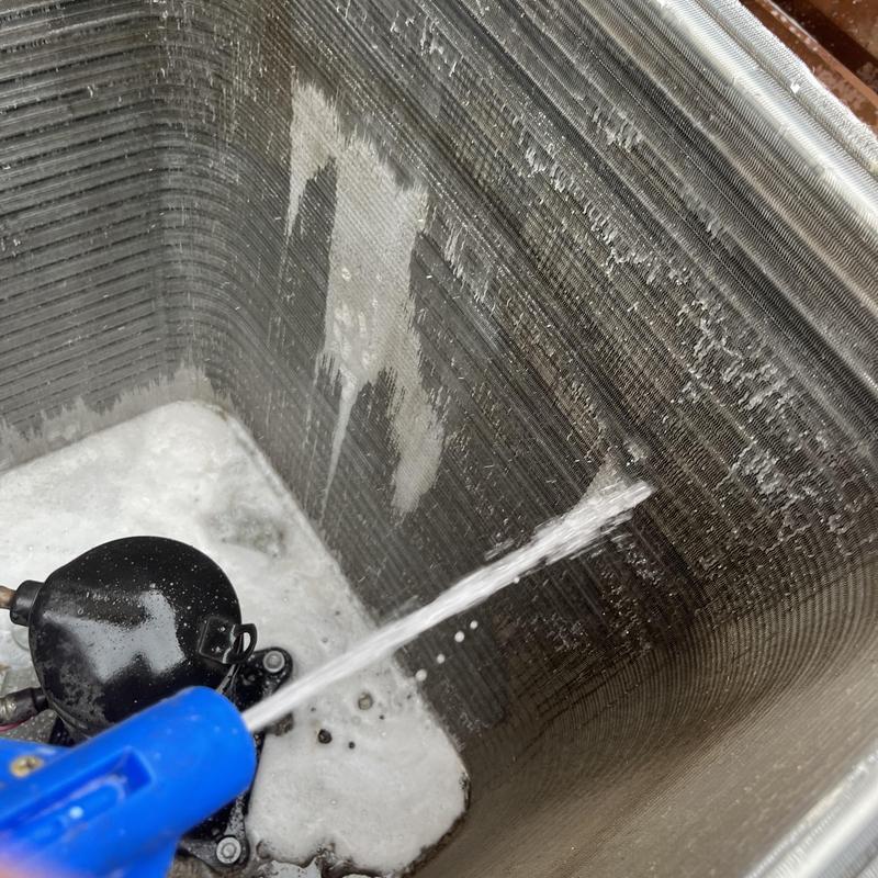 Condenser coil cleaning with water spray and foam