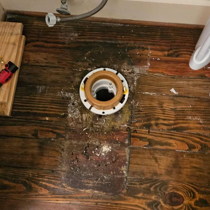 Toilet flange installation on wooden floor planks