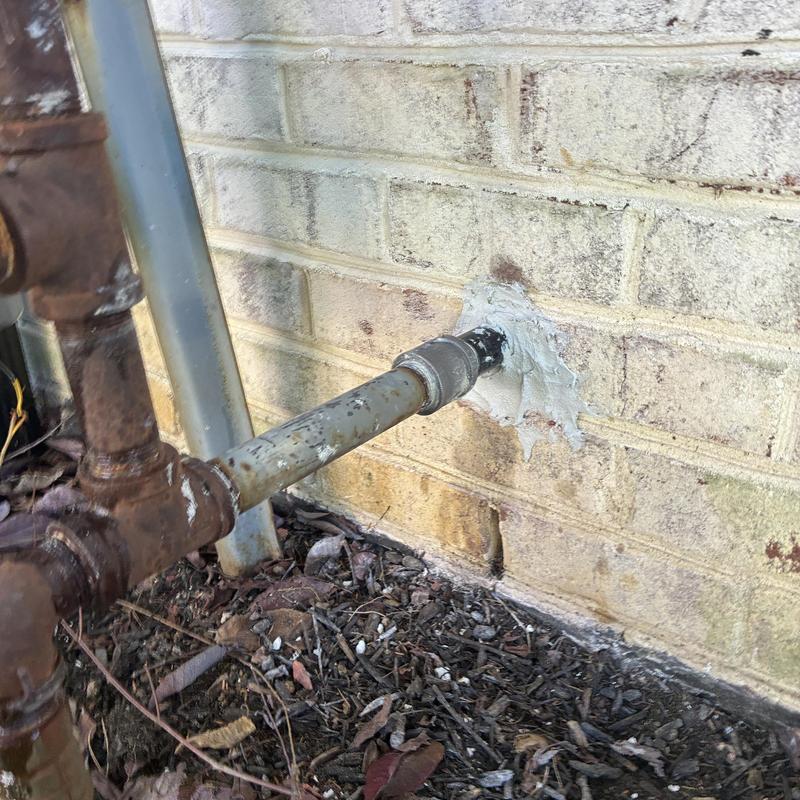 Gas main pipe with exterior wall sealant patch