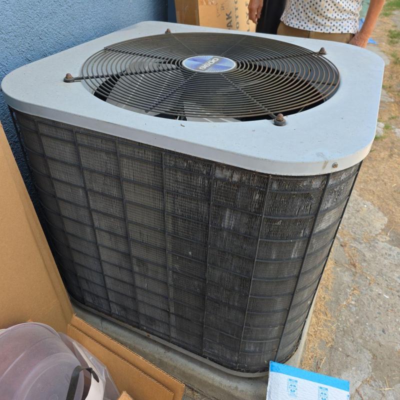 Condenser unit with protective grille and fan blades