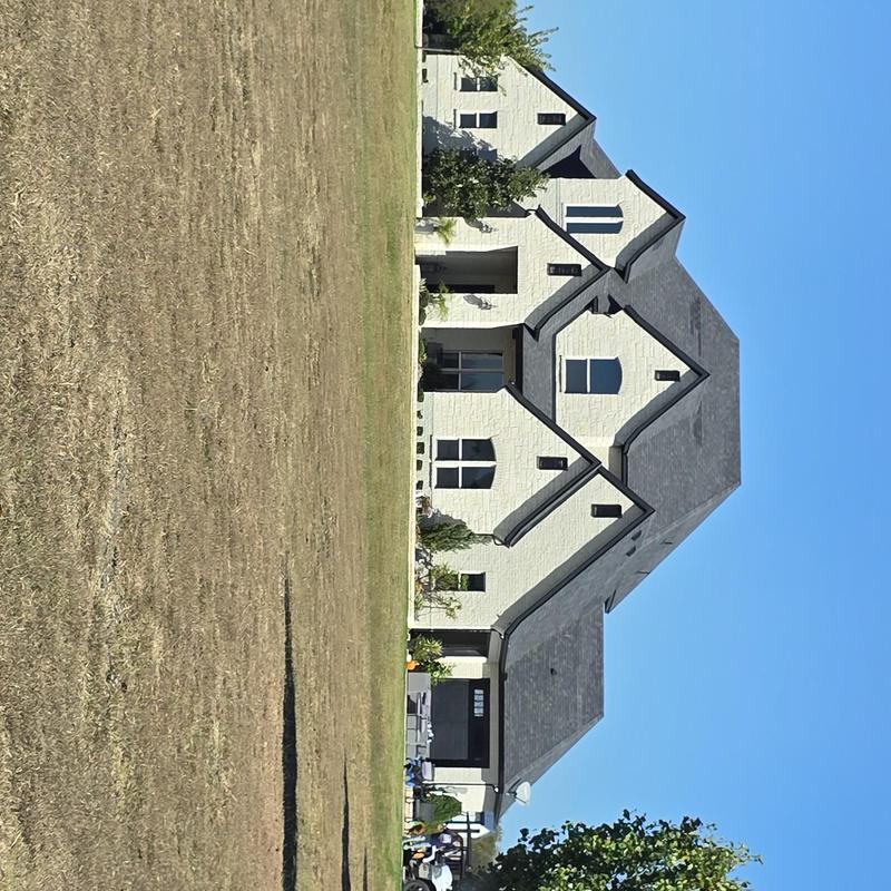 Roof shingles and structure of white house in sun