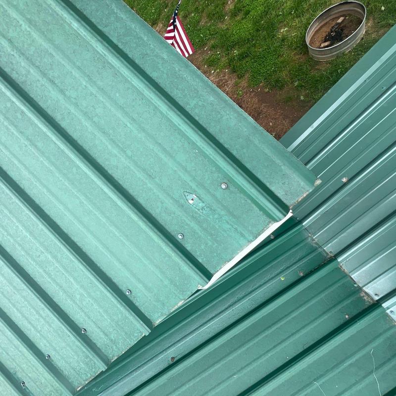 Metal roofing panels with repaired ridge valley seams