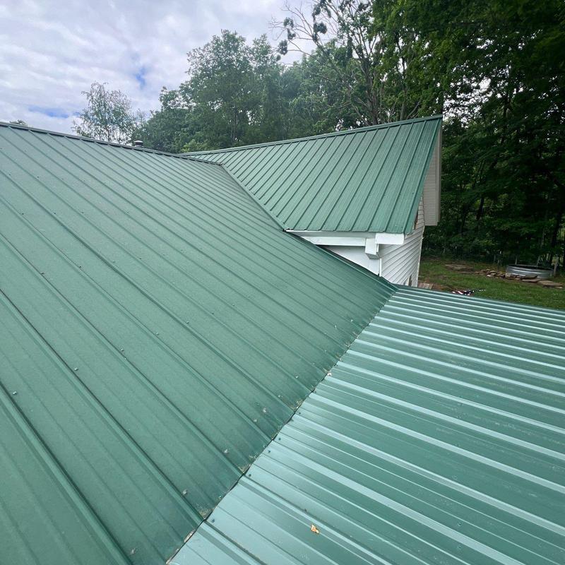 Green metal roofing panels on residential home