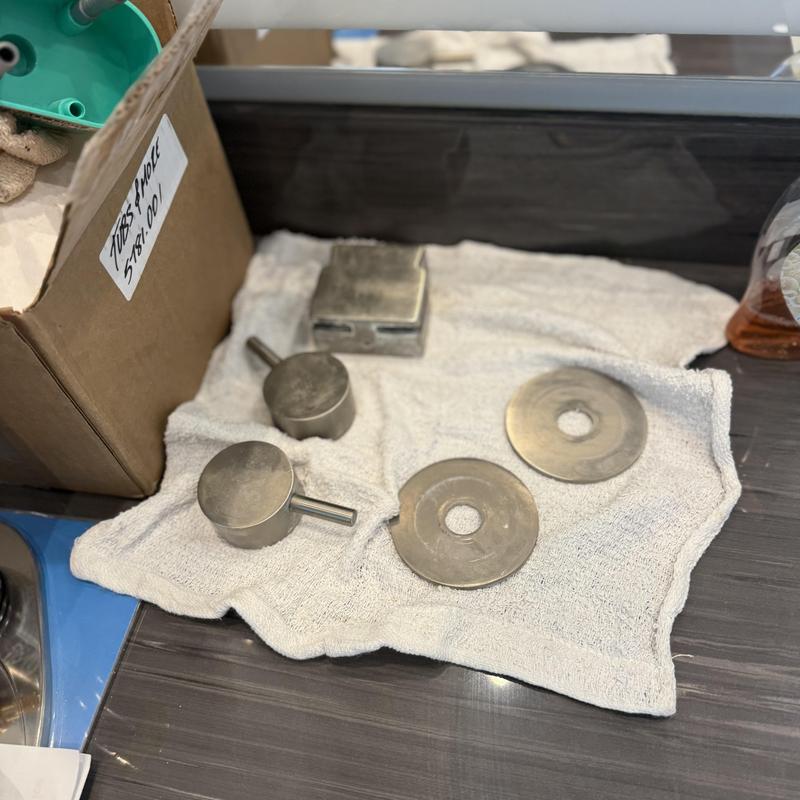 Shower trim parts on towel for tile repair preparation