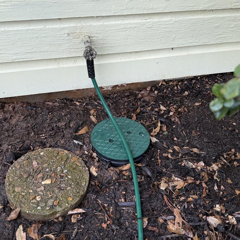 Main water line shut-off valve with green hose attached