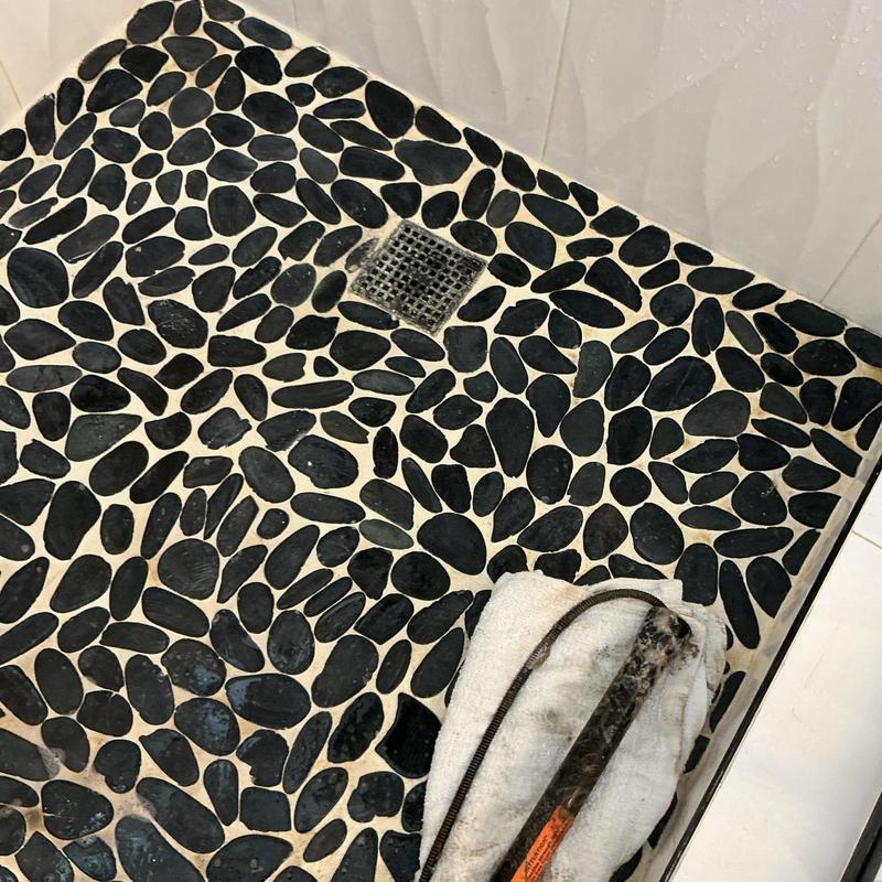 Shower drain with hand snake and debris removal