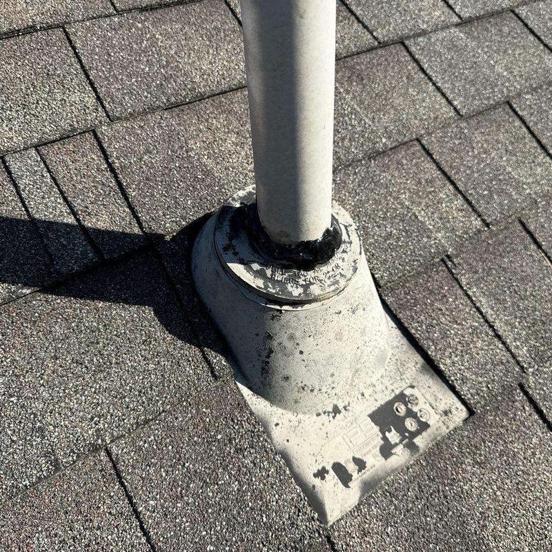 Roof pipe flashing with sealant on shingle roof