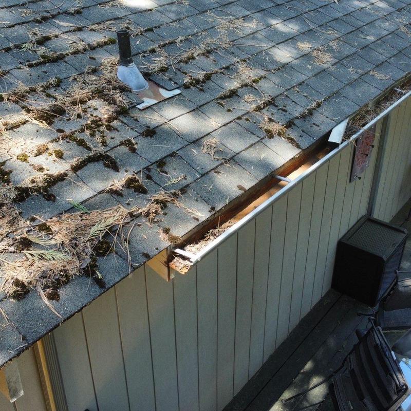 Asphalt shingle roof with damaged gutter edge and debris Asphalt shingle roof with damaged gutter edge and debris