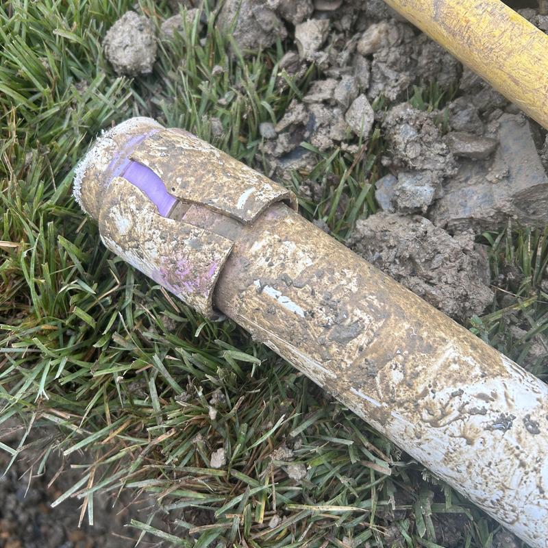 2-inch PVC water main with cracked section in soil