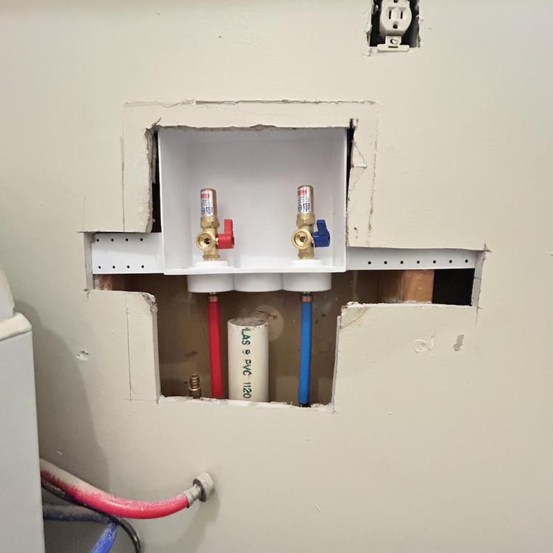 Washer box with red and blue valves installed in wall