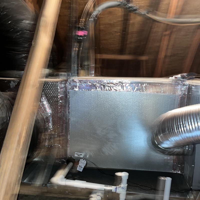 Air handler unit with duct and PVC piping in attic