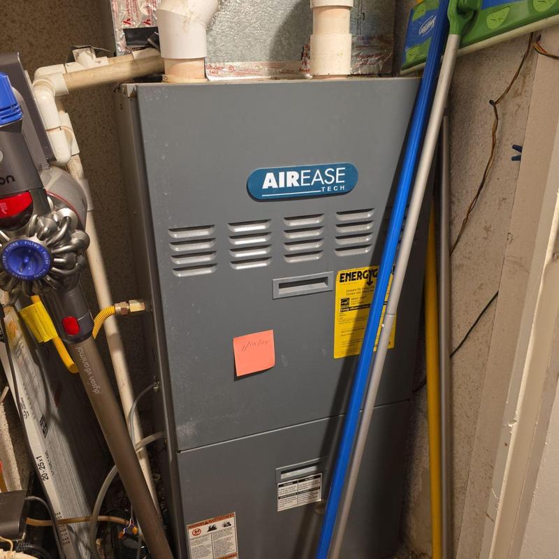 Furnace unit with AIR EASE Tech logo and pipes nearby