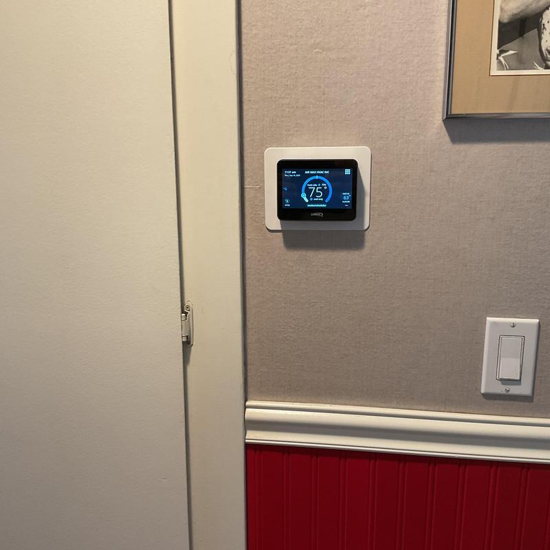 Smart thermostat installation on beige wall panel