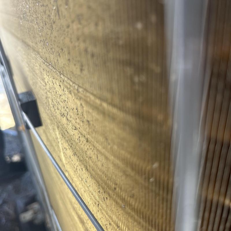 Air conditioner condenser coil close-up with dirt buildup