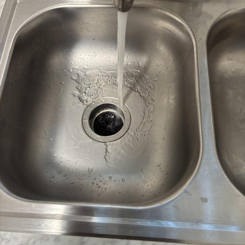 Kitchen sink drain with running water cleaning