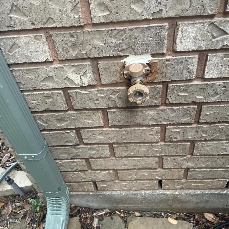 Outdoor hose bib on brick wall with new fitting