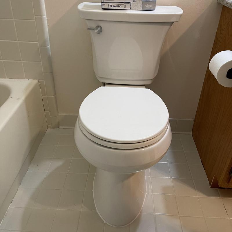 Toilet installation in bathroom with tiled floor